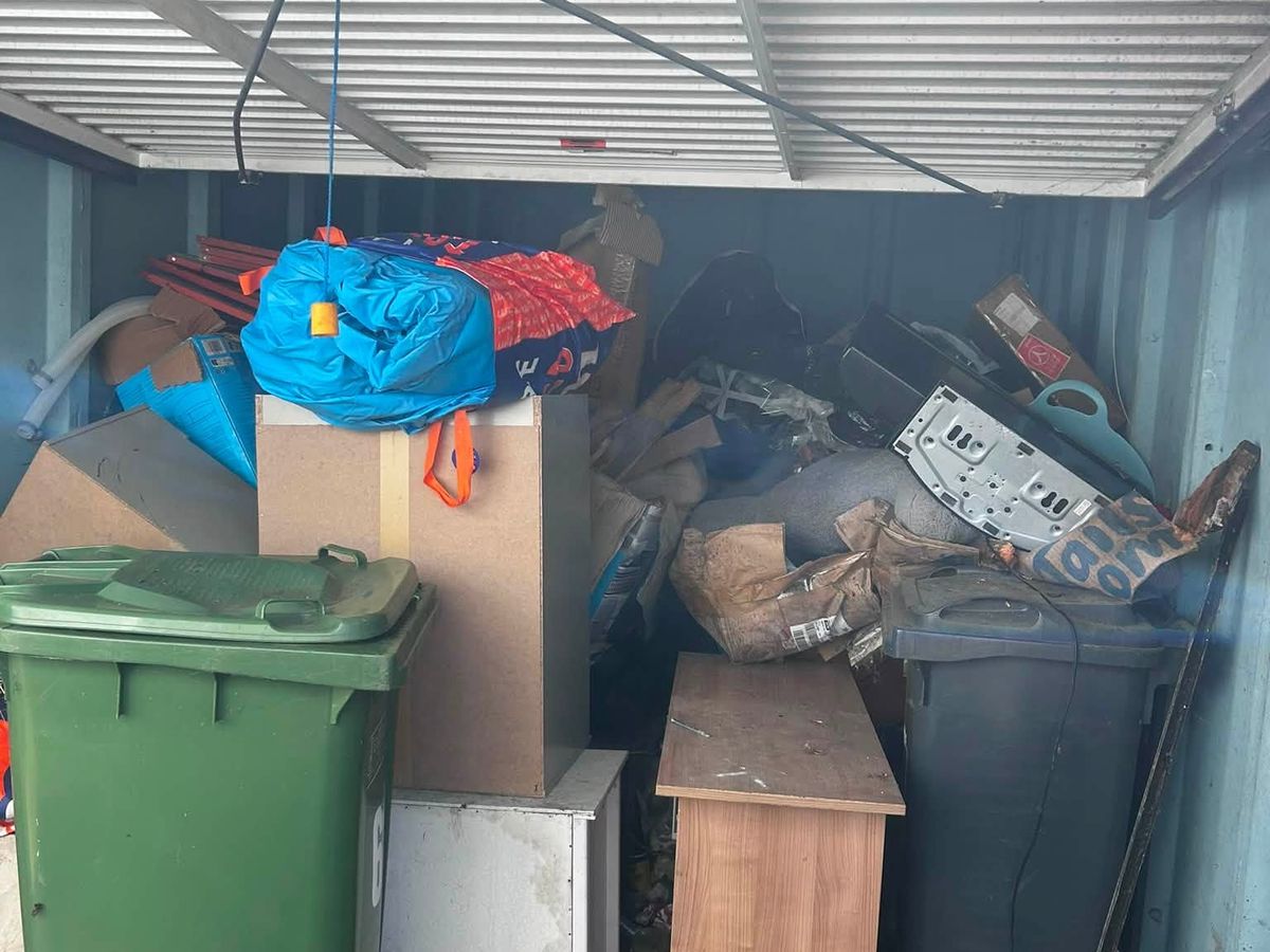 Garage in Castle Vale packed floor to ceiling with old furniture, bins and household junk before clearance