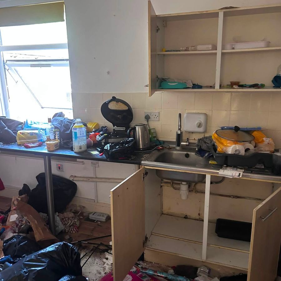 Kitchen buried in rubbish at the start of a full house clearance in Birmingham
